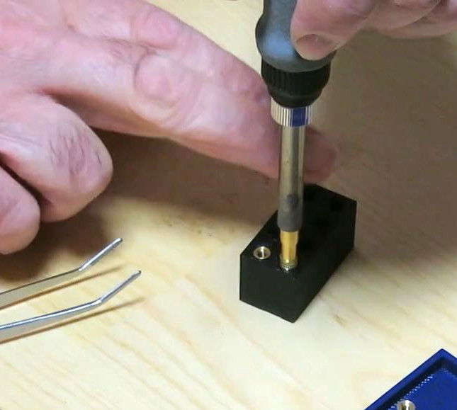 Gently pressing the hot insert into the hole