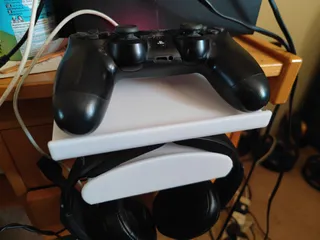 Desk clamp to house over-ear headphones with a platform for a games controller or phone.