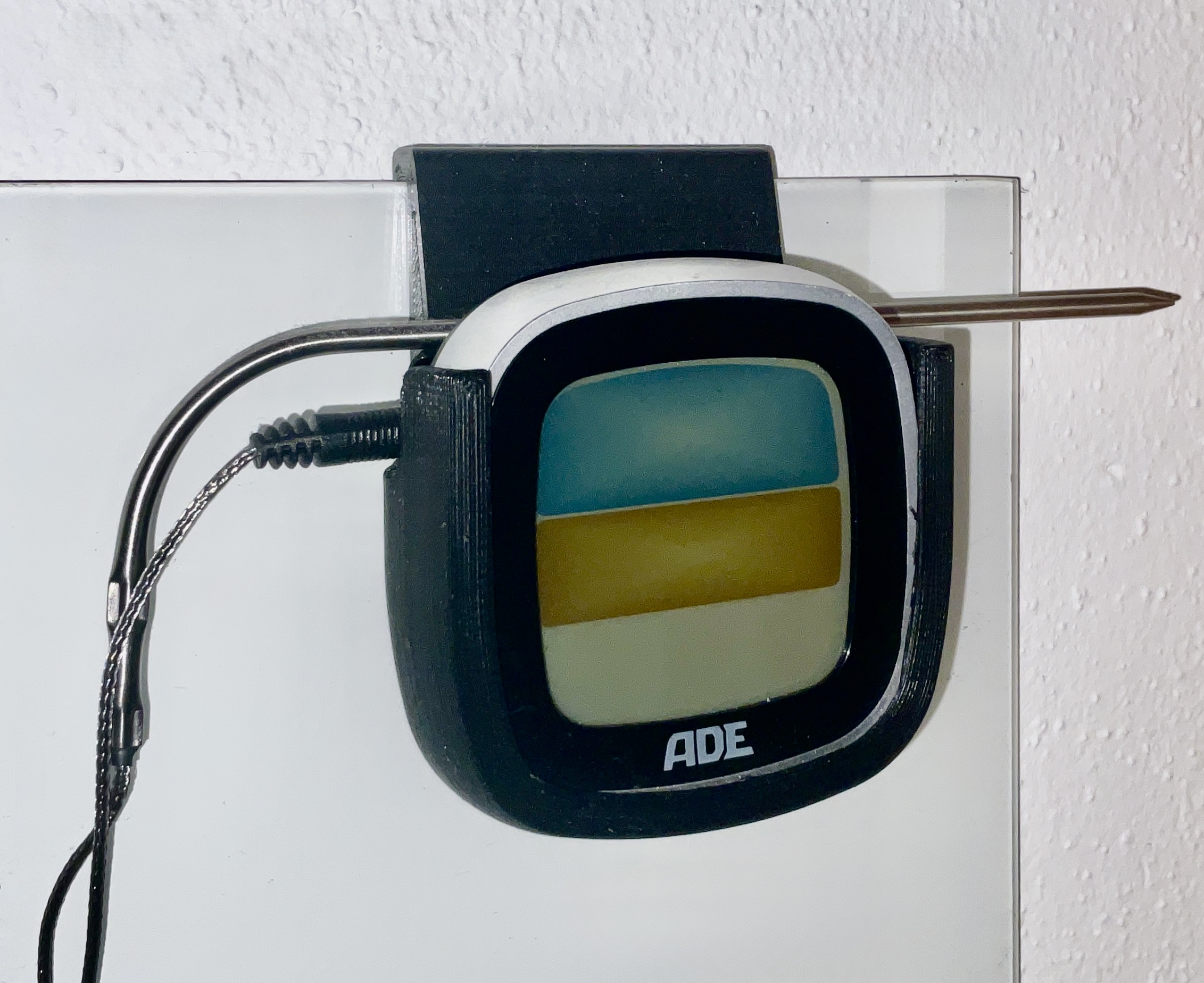 Holder to fix thermometer to a wall mounted pin board