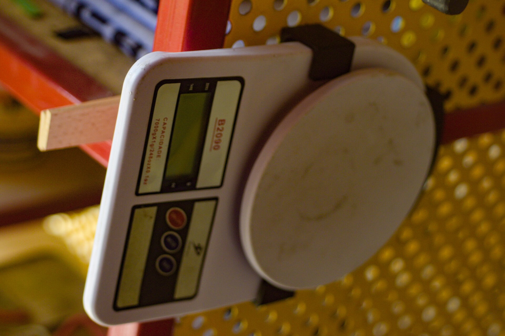 Holder for a common electronic scale, for perforated steel boards and Skadis