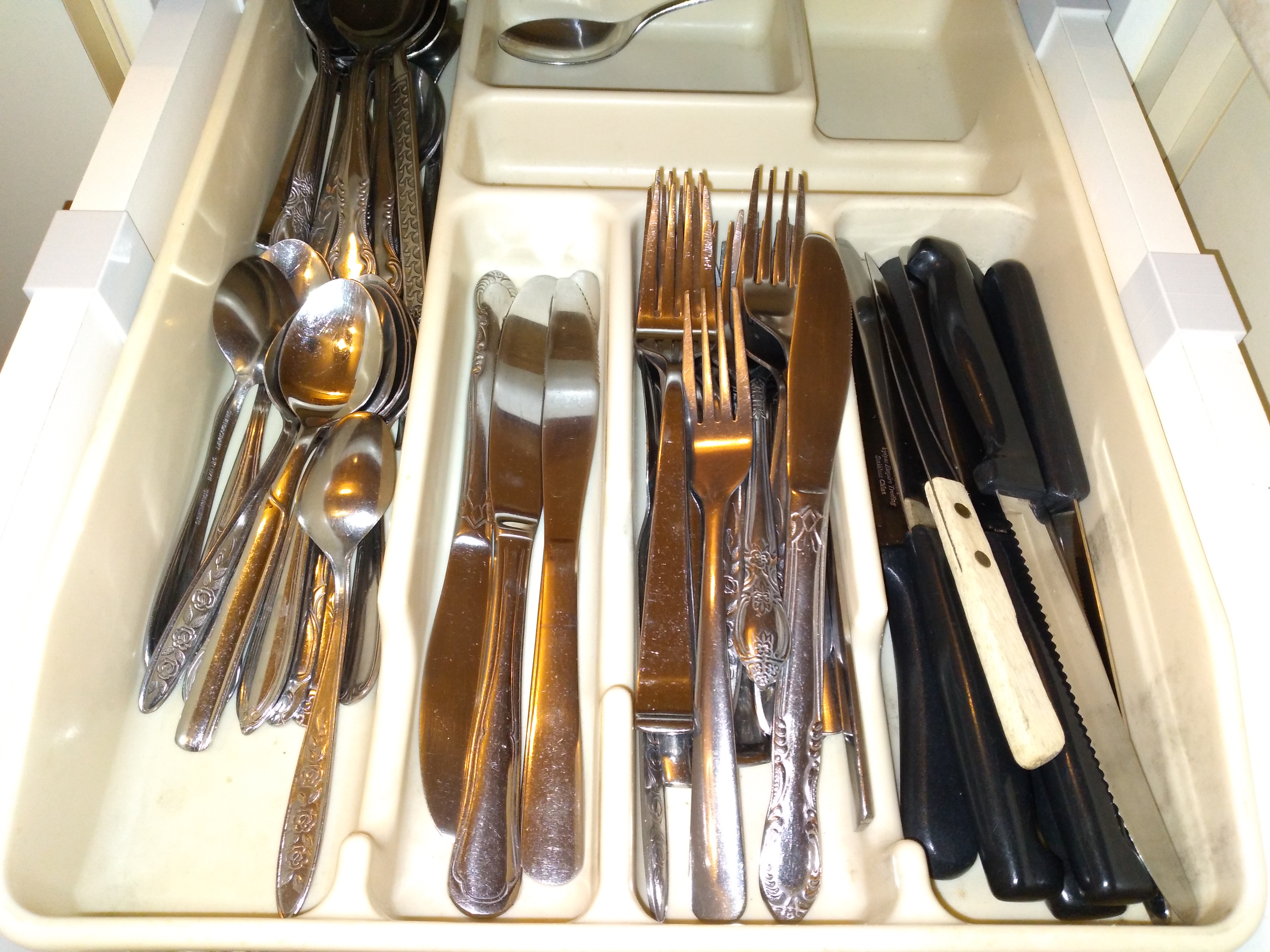Hook to hold kitchen utensil tray in the drawer