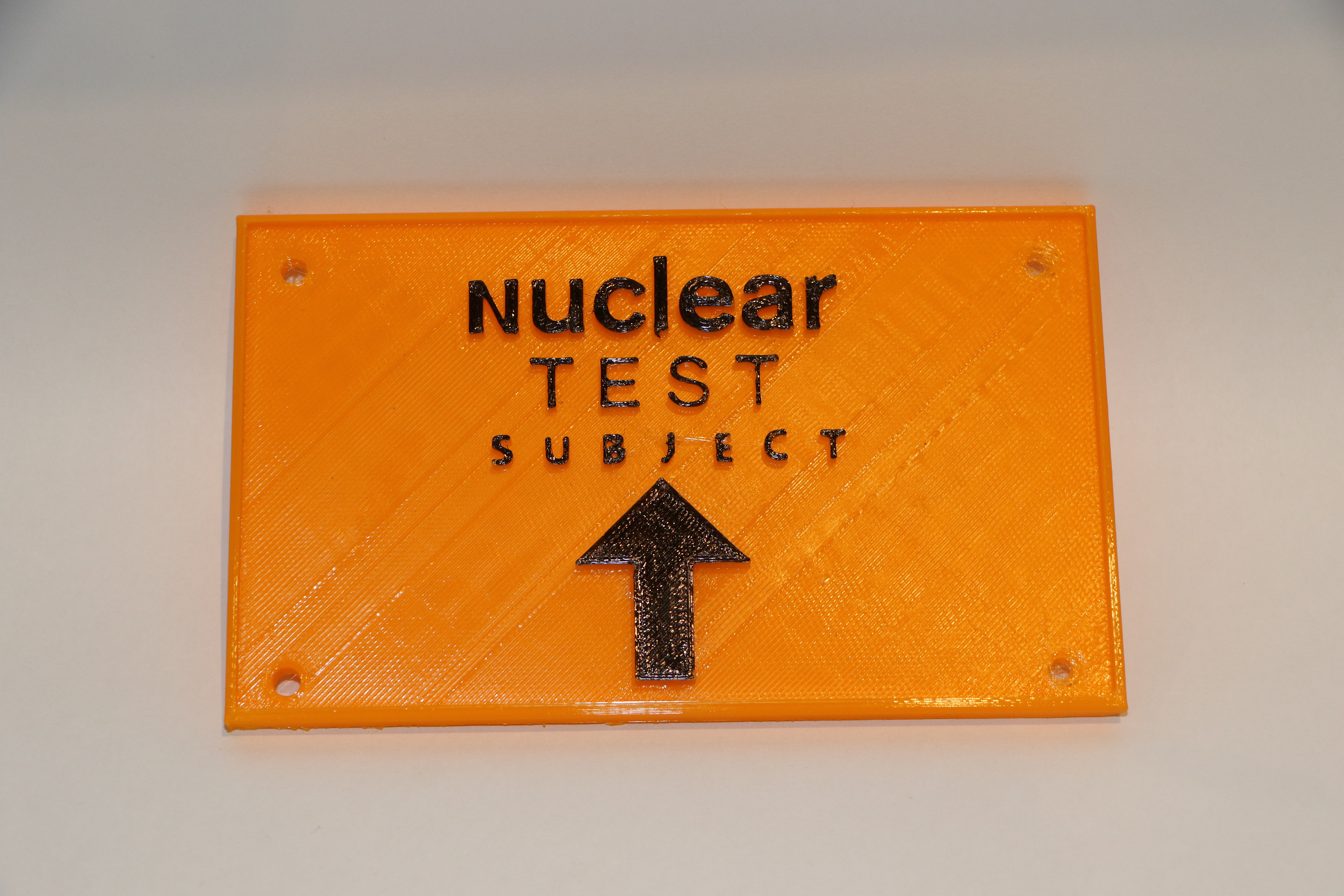 A funny sign that says "nuclear test subject" with and arrow