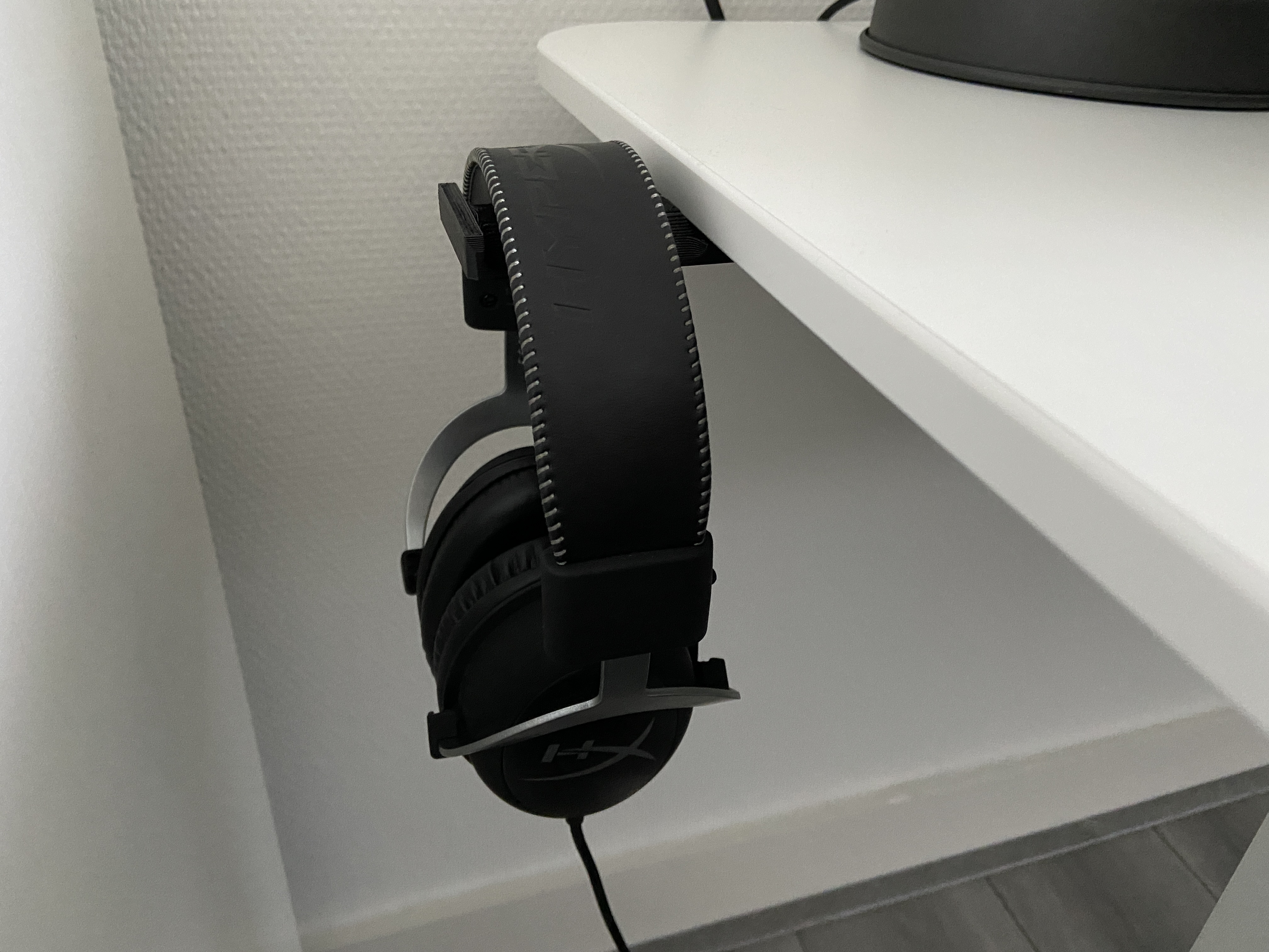 Headphone holder beside desk top.