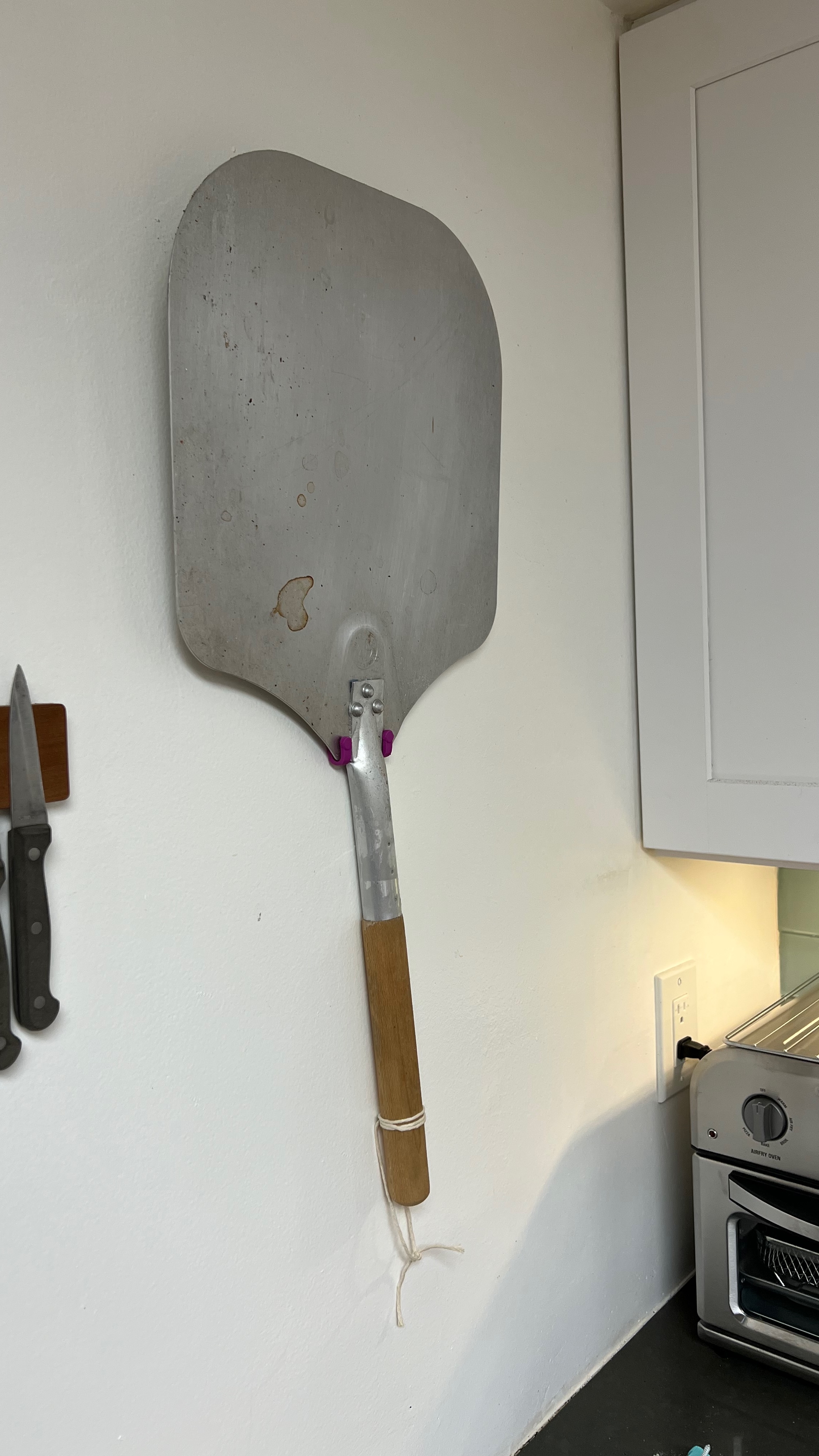 Slimline wall-mounted pizza peel hook