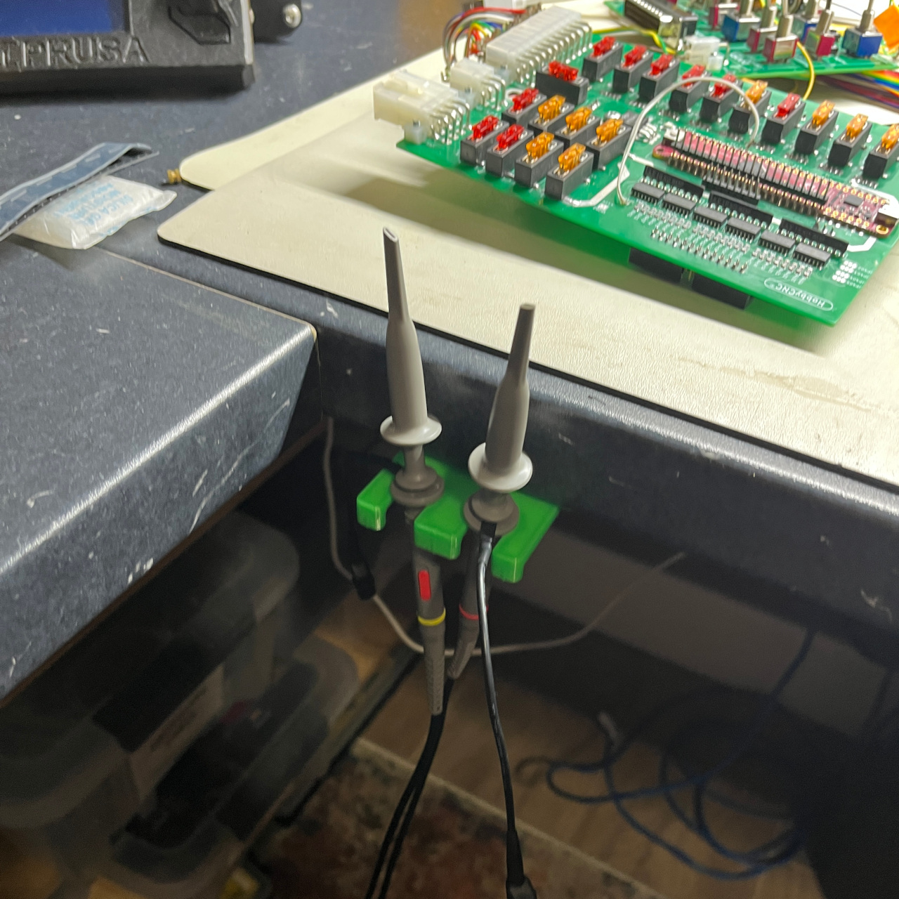 Retractable under-bench scope/voltmeter probe holder
