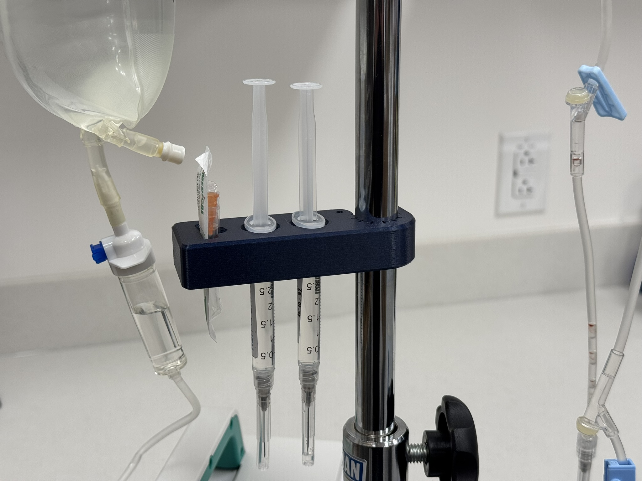 Syringe holder with IV pole clamp and needle holder
