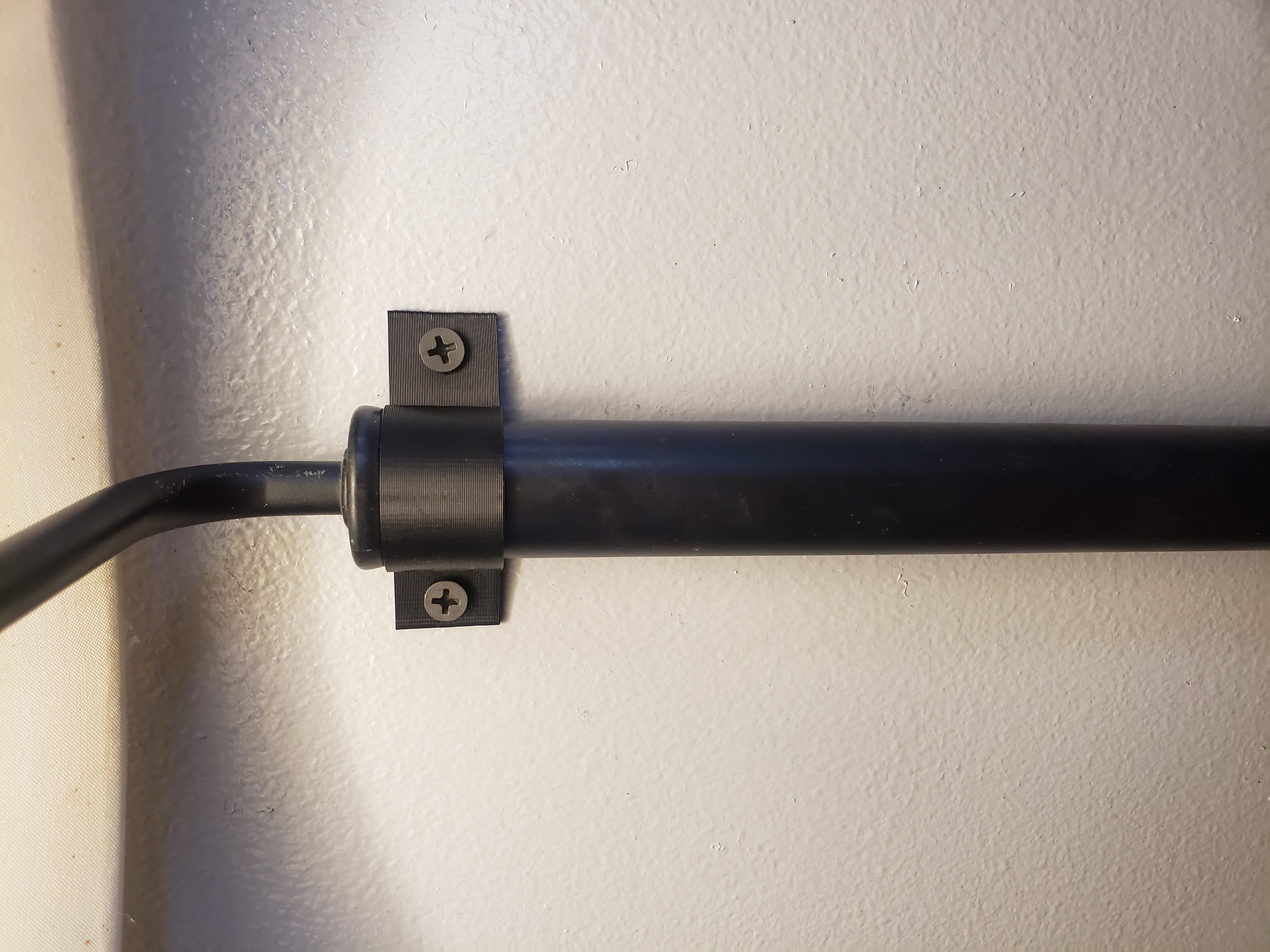 A clamp I made to hang a lamp rod on the wall that came off an old end table