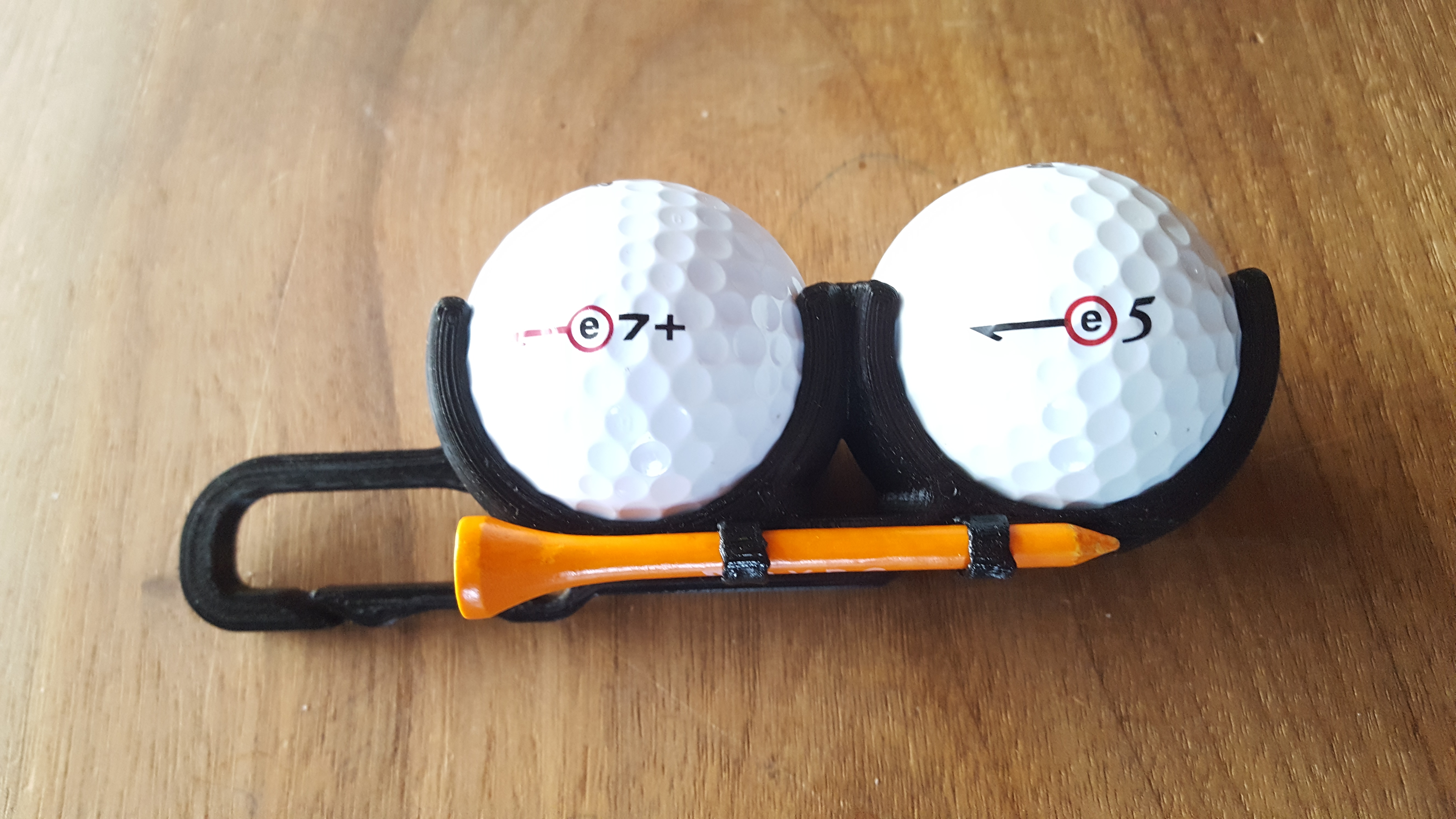 Golf ball holder with integrated tee slot