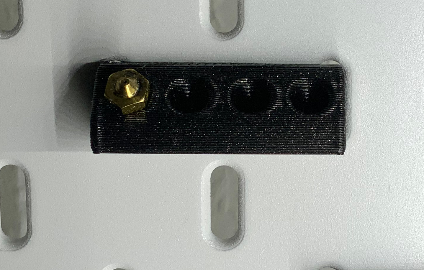 Nozzle holder for IKEA Skadis Pegboard