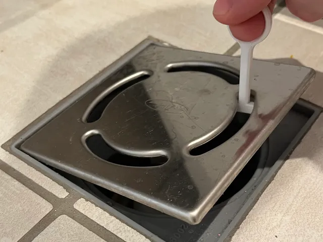 Shower drain grate opener