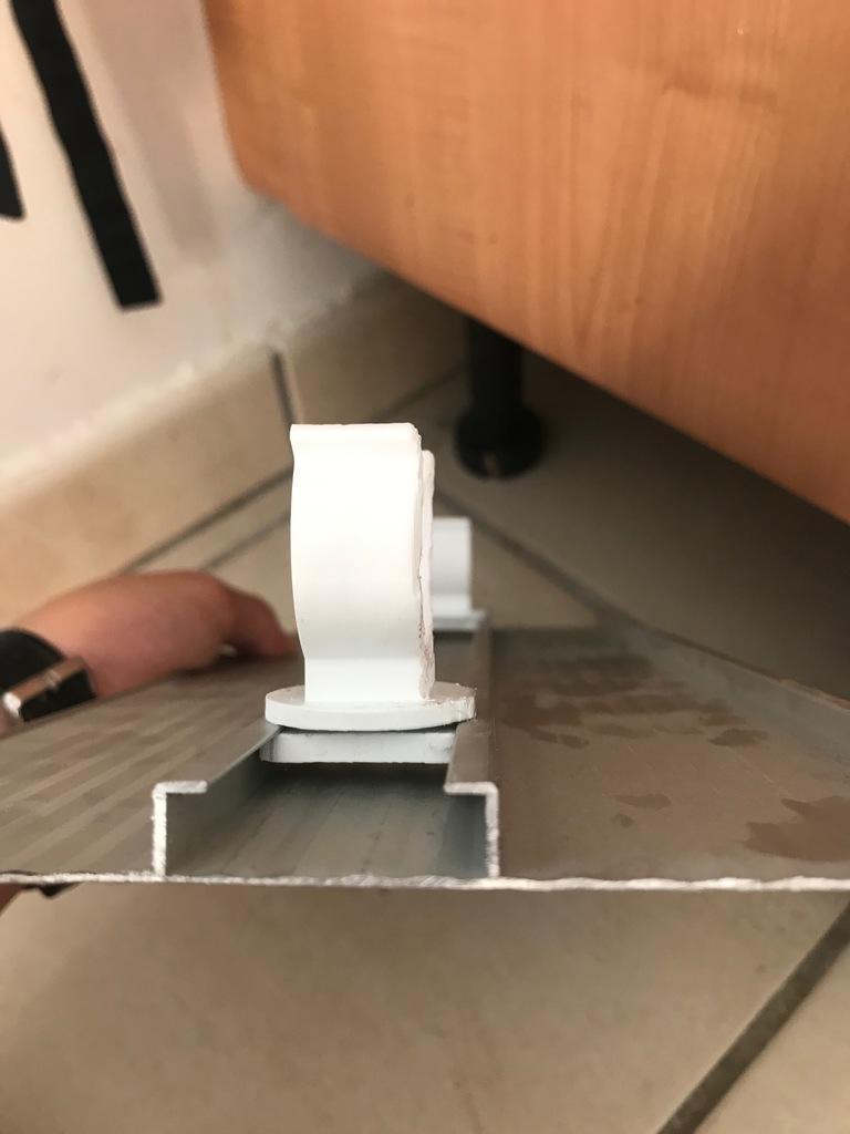 Fixation pour pied de meuble de cuisine sur rack/rail/plainte