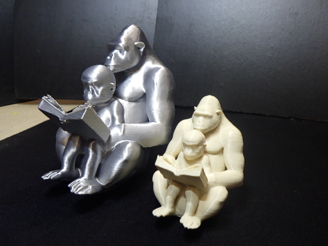Gorilla reading to baby gorilla.