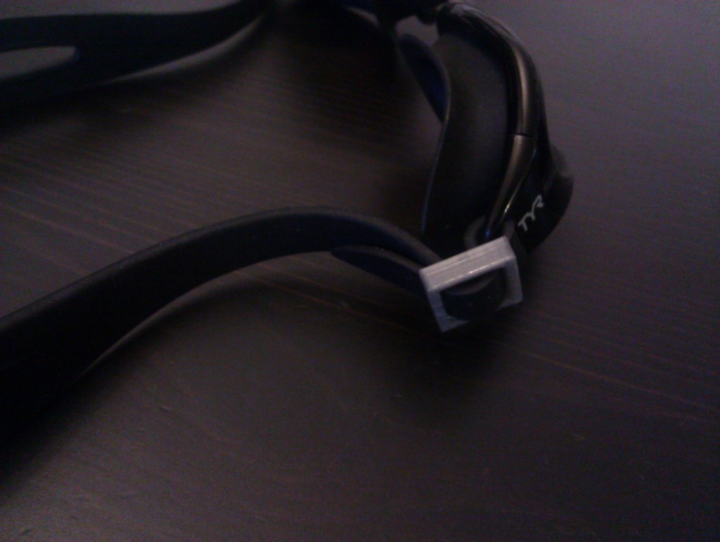 Tightening clip for swimming goggles