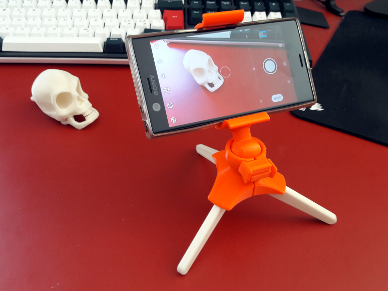 Phone tripod with squeeze mechanism