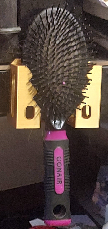 Hairbrush holder for sheetmetal shelving