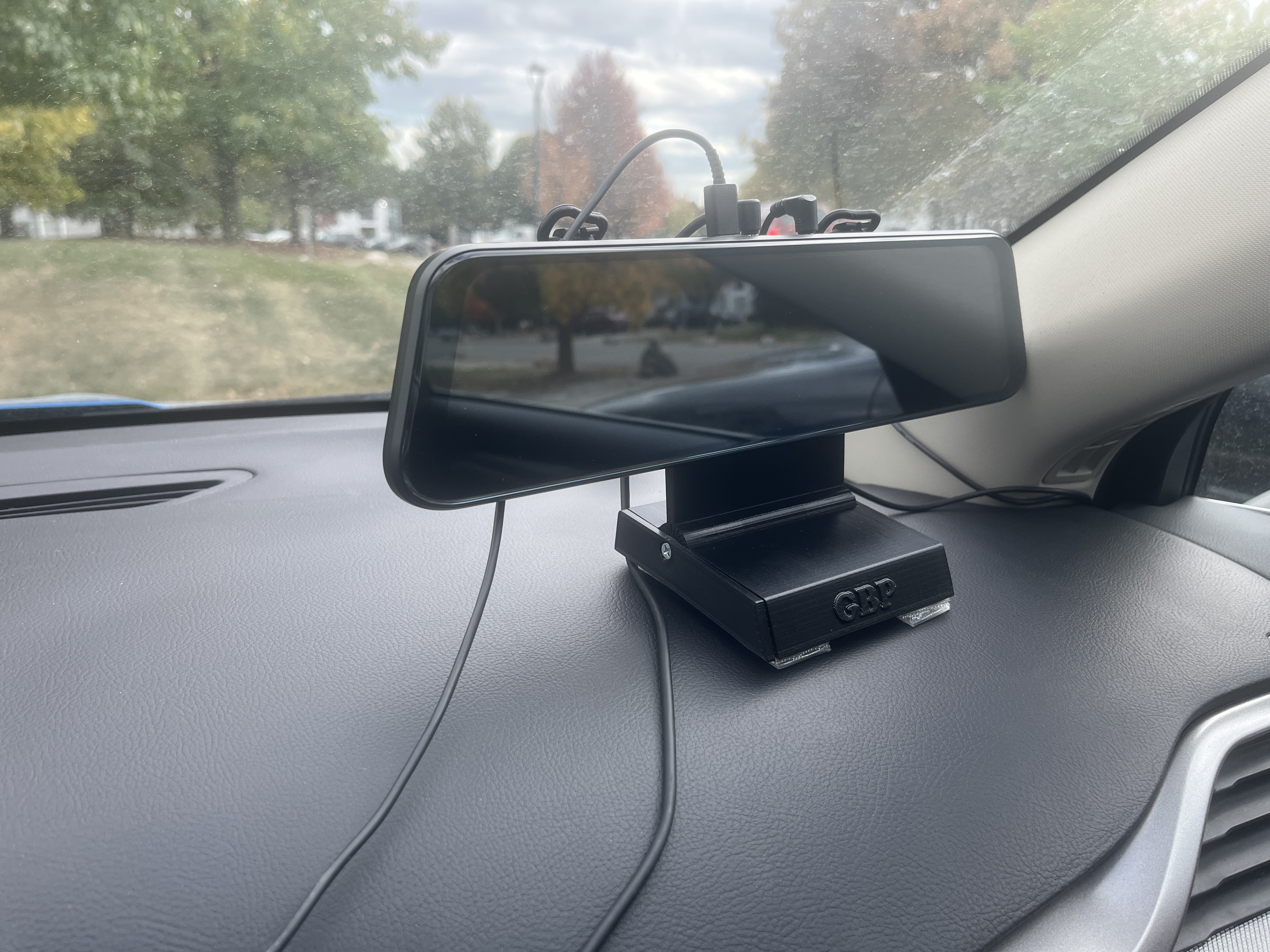 Adjustable center console mount for a rear view mirror style dash camera.
