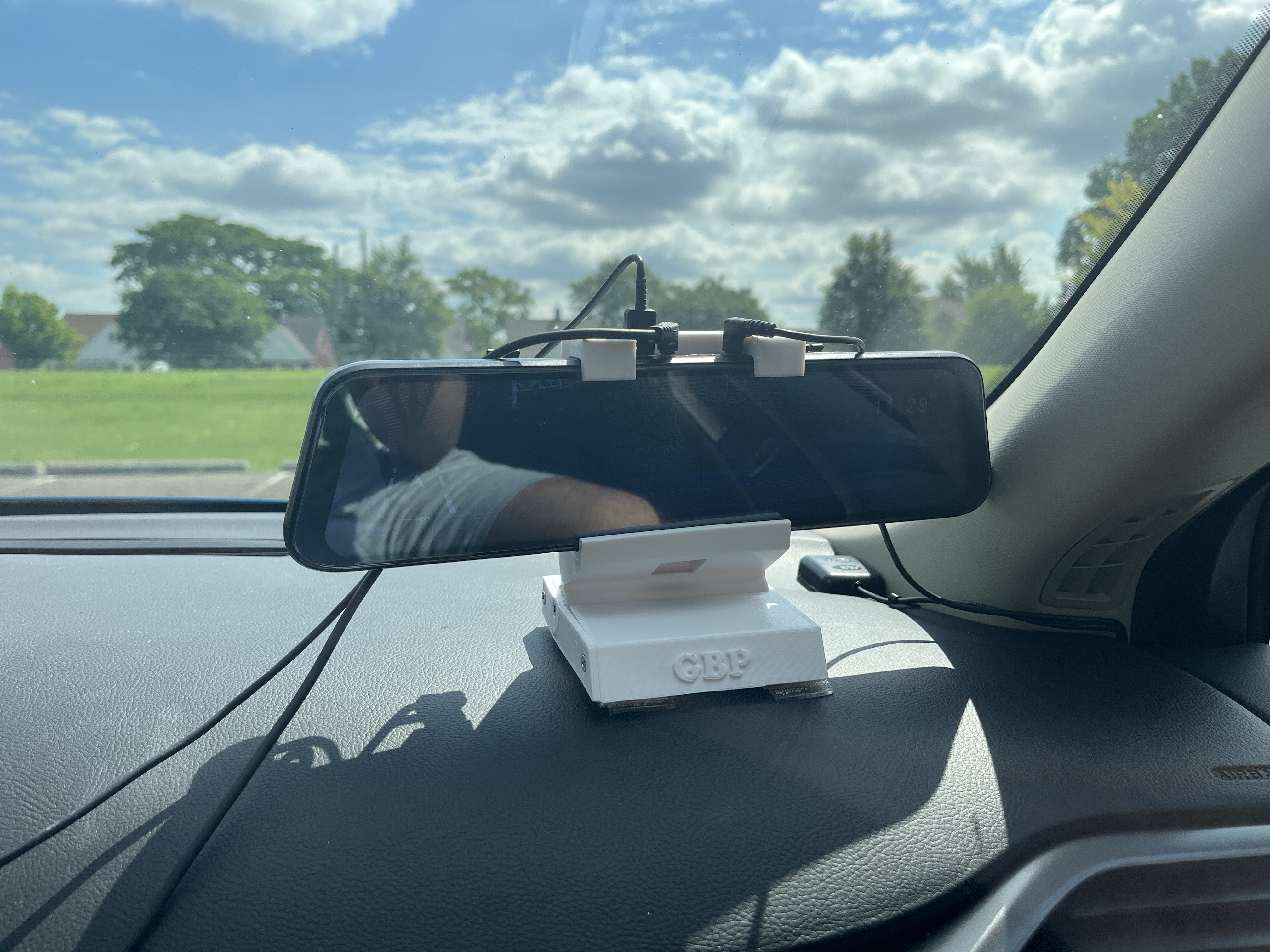 Adjustable center console mount for a rear view mirror style dash camera.