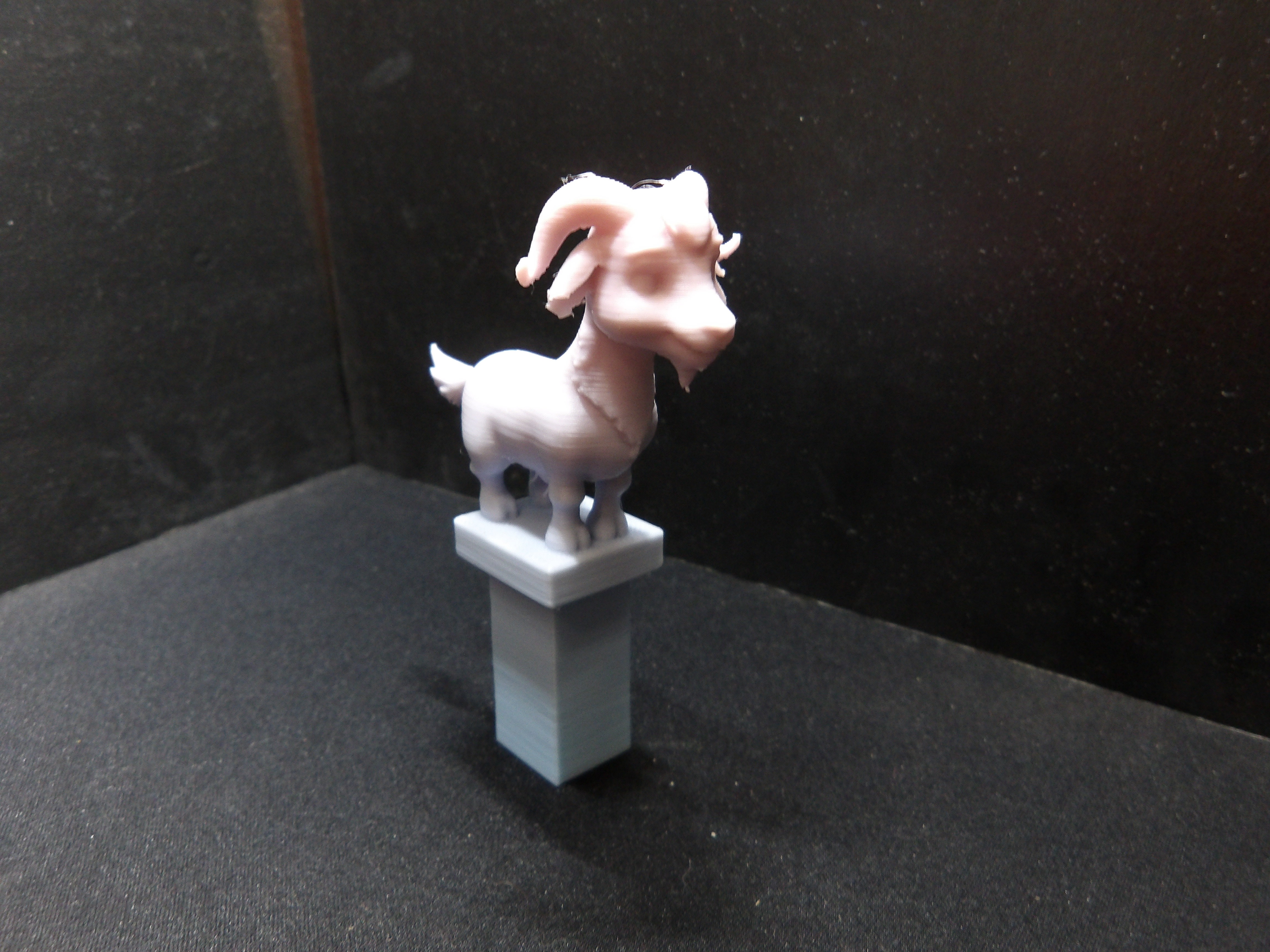 Cute goat on a pedestal.