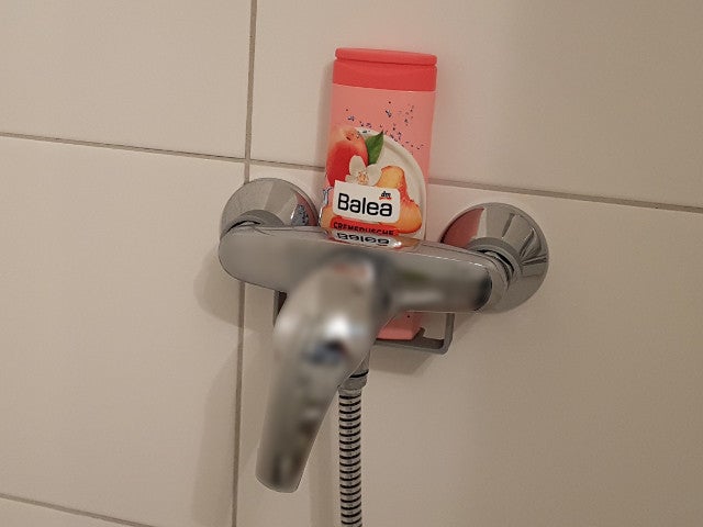 Almost invisible shower gel bottle holder