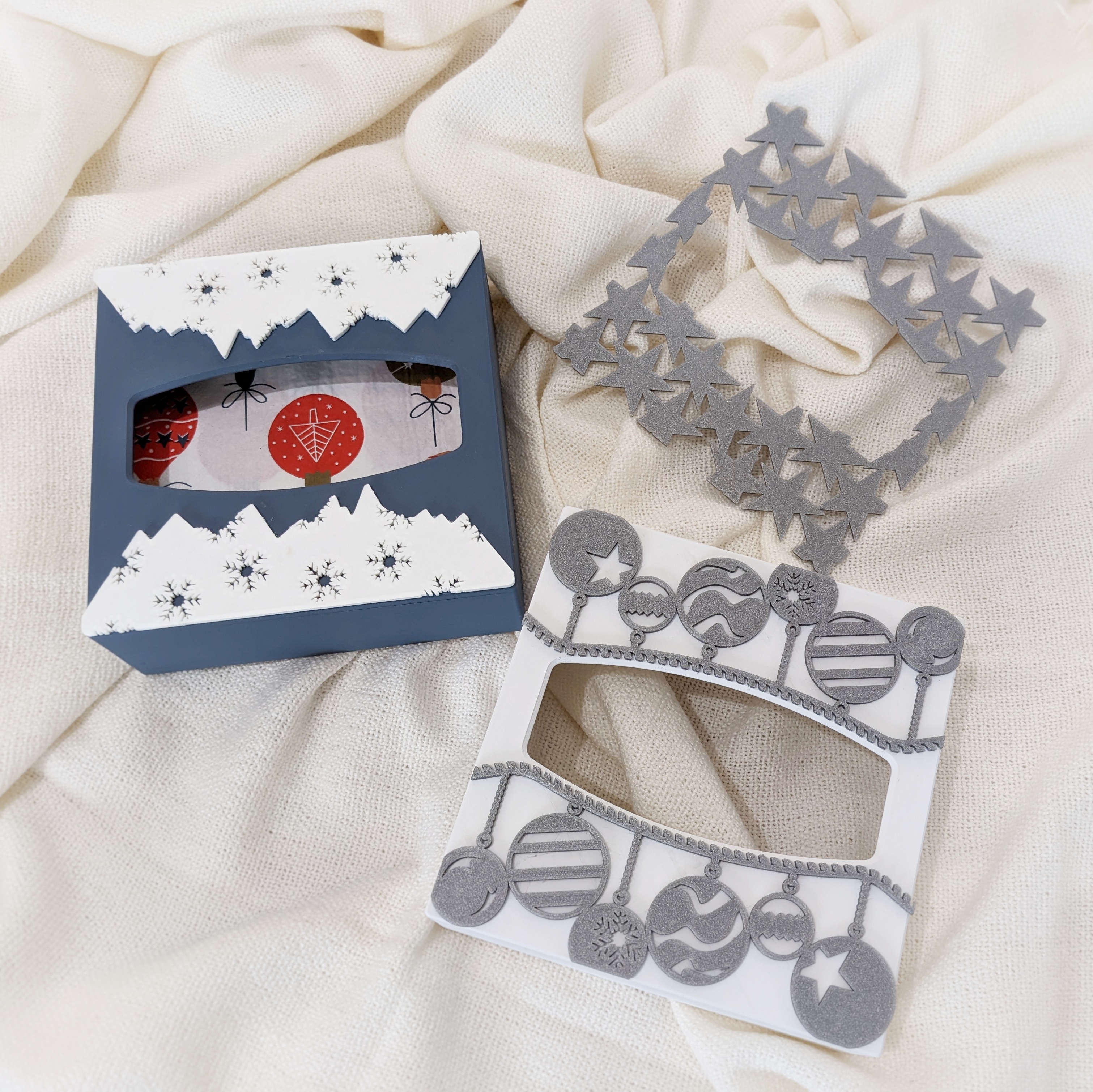 Napkin holder with interchangeable and customizeable decorations (christmas balls, stars, mountains with snow flakes...)