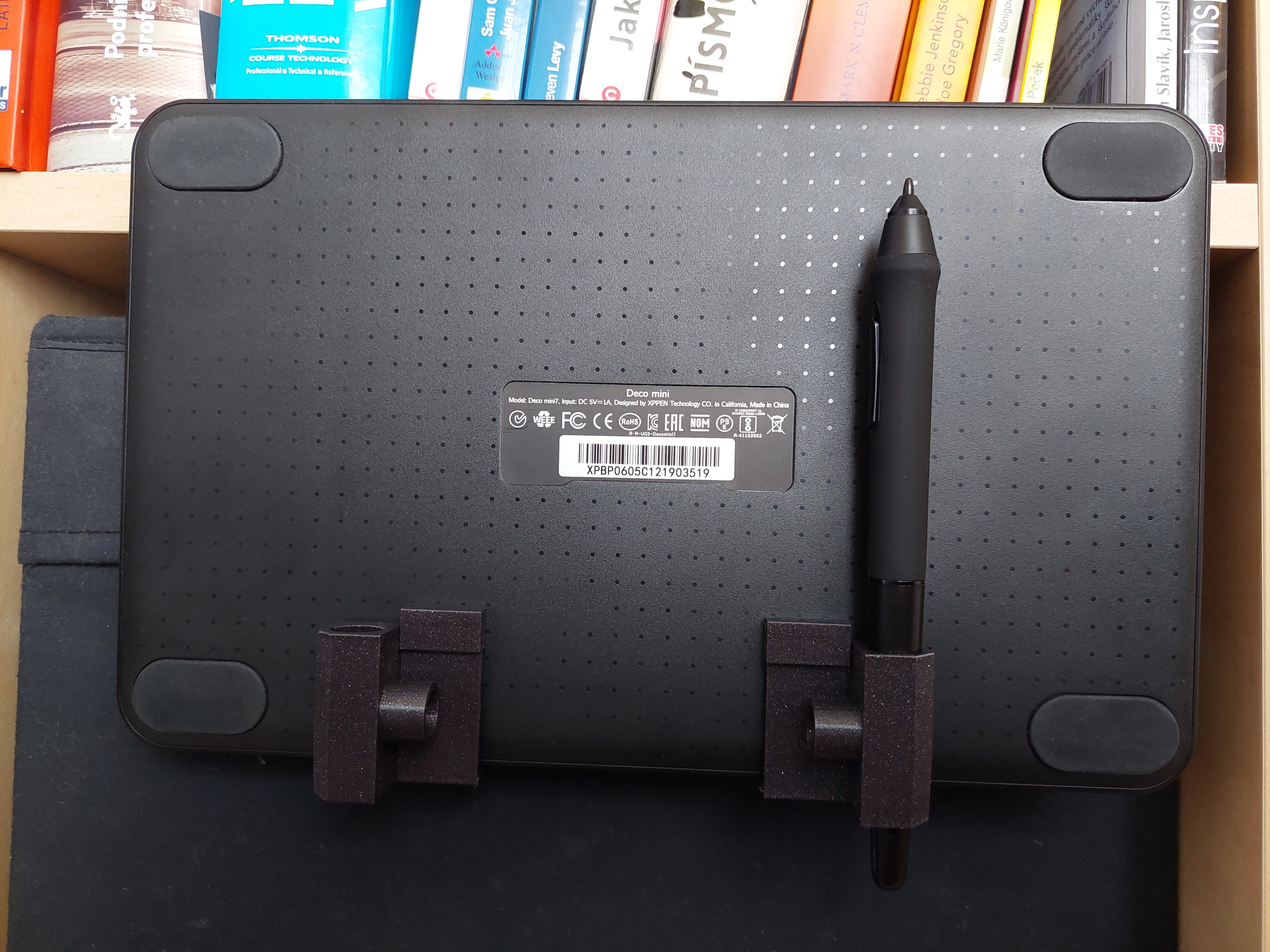 Universal graphics tablet holder for bookcase by plachytomas.cz