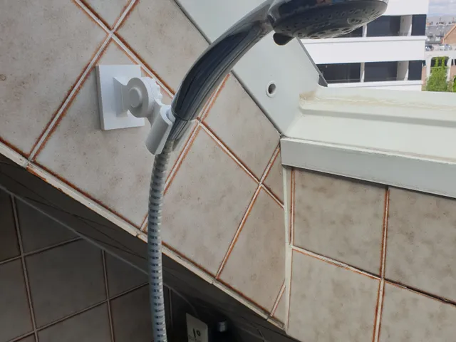 Adjustable shower head holder