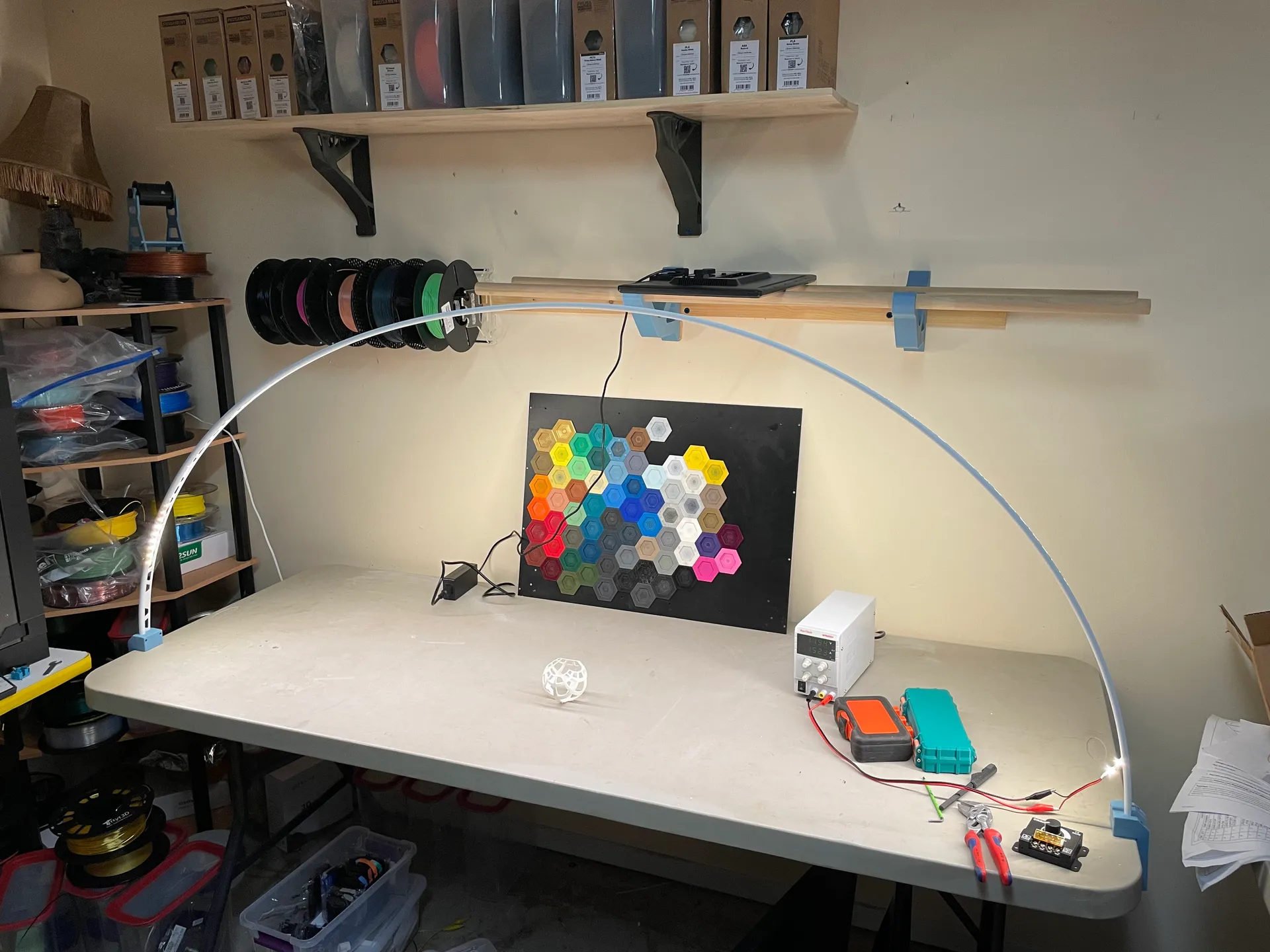 A PVC arch with strip leds and clamps holding it to a table