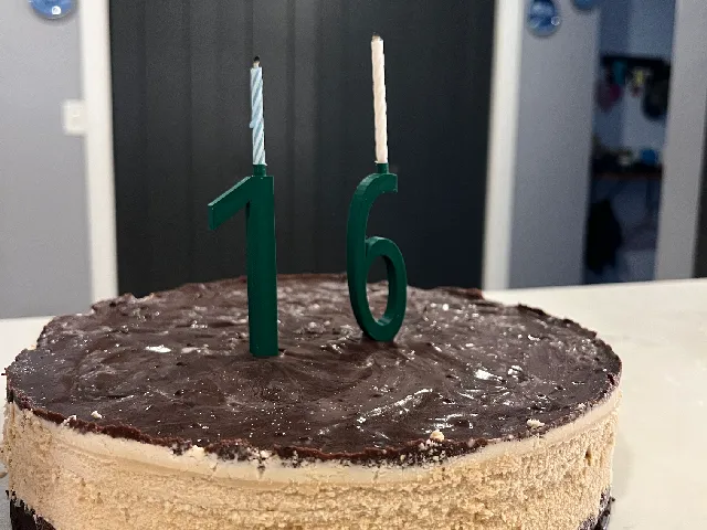 candle holding birthday cake numbers