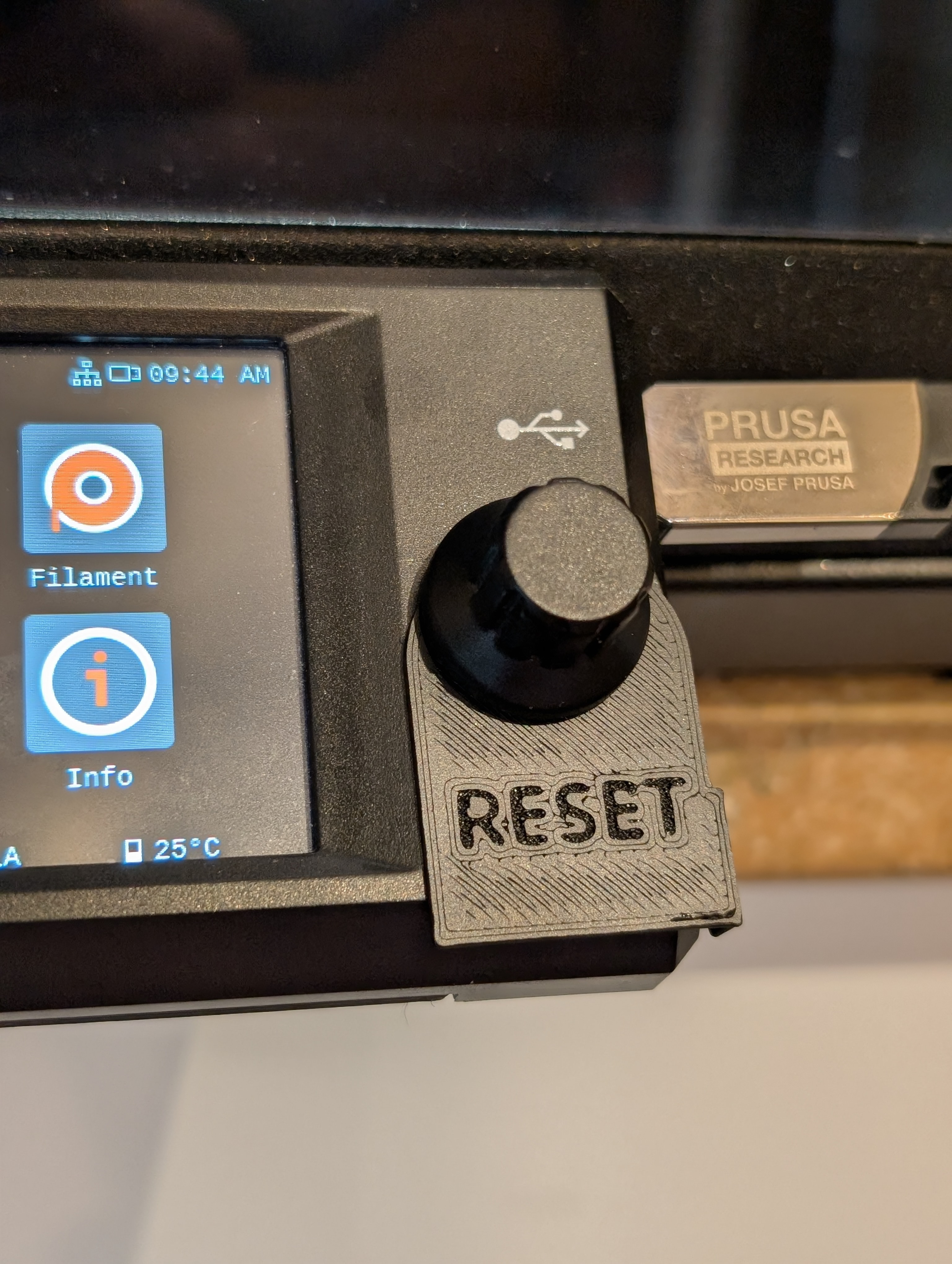 A swinging reset cover for the Prusa Core One