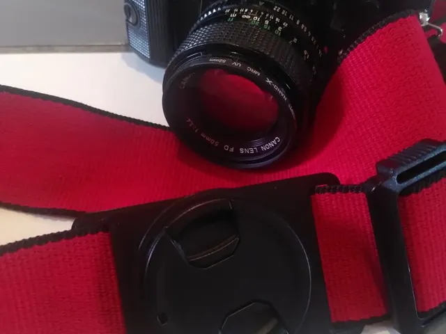 Attach lens cap to camera strap
