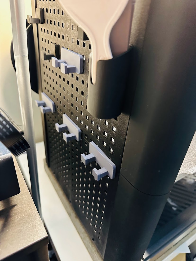 Double spaced pegboard hook connector for minimal shell enclosure