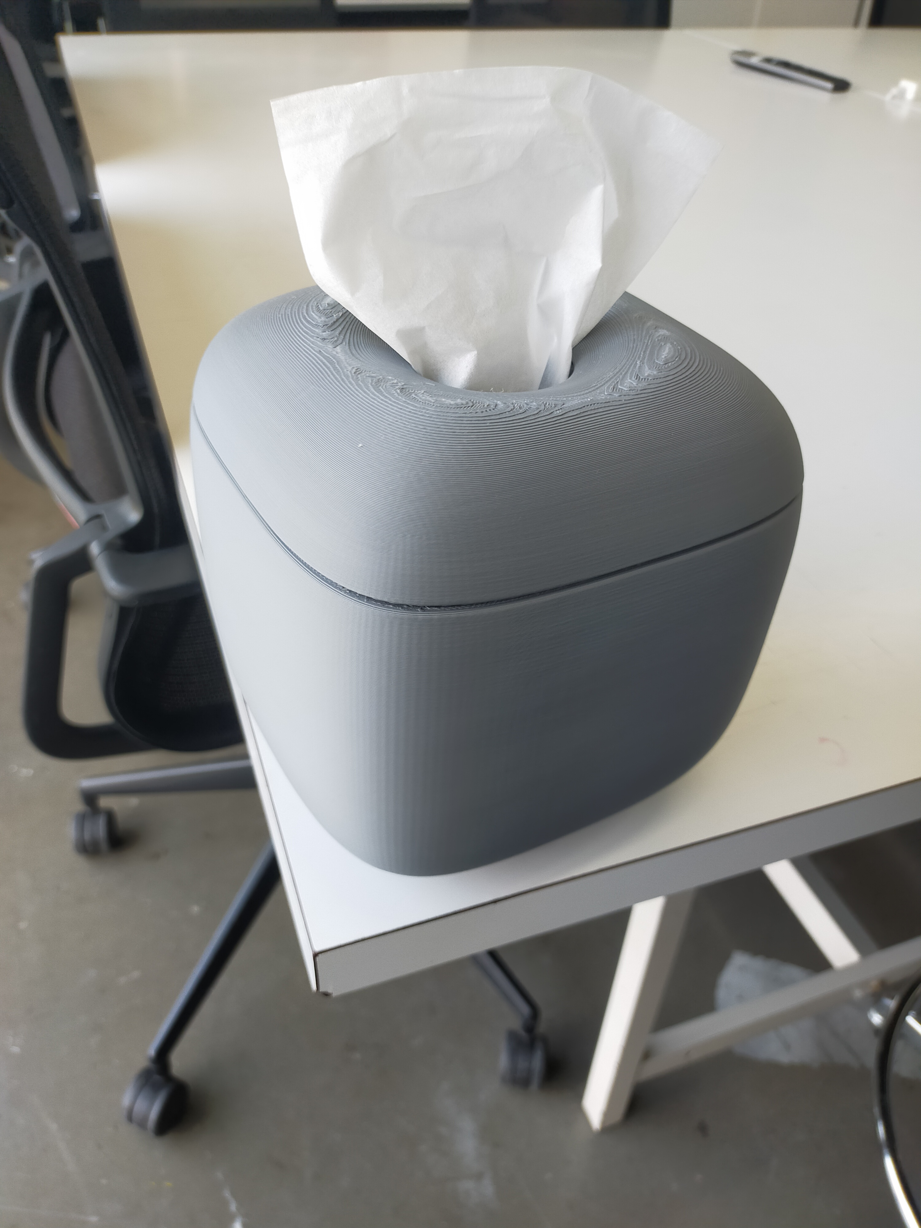 A tissue box that has a shape resembling a combination of a sphere and a cube.