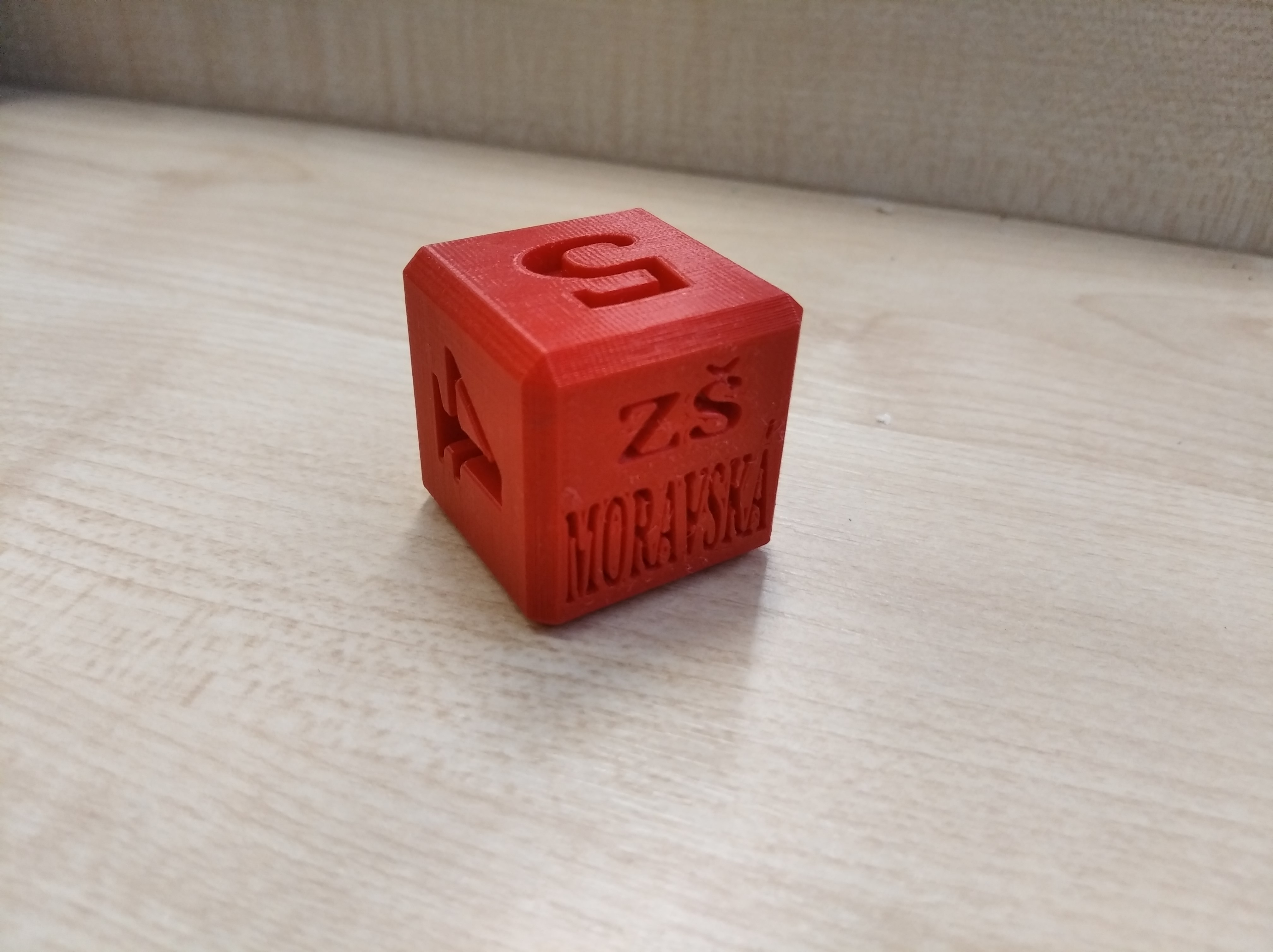 Hrací kostka s logem místo 6ky.