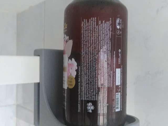 Shampoo bottle holder for shower wall