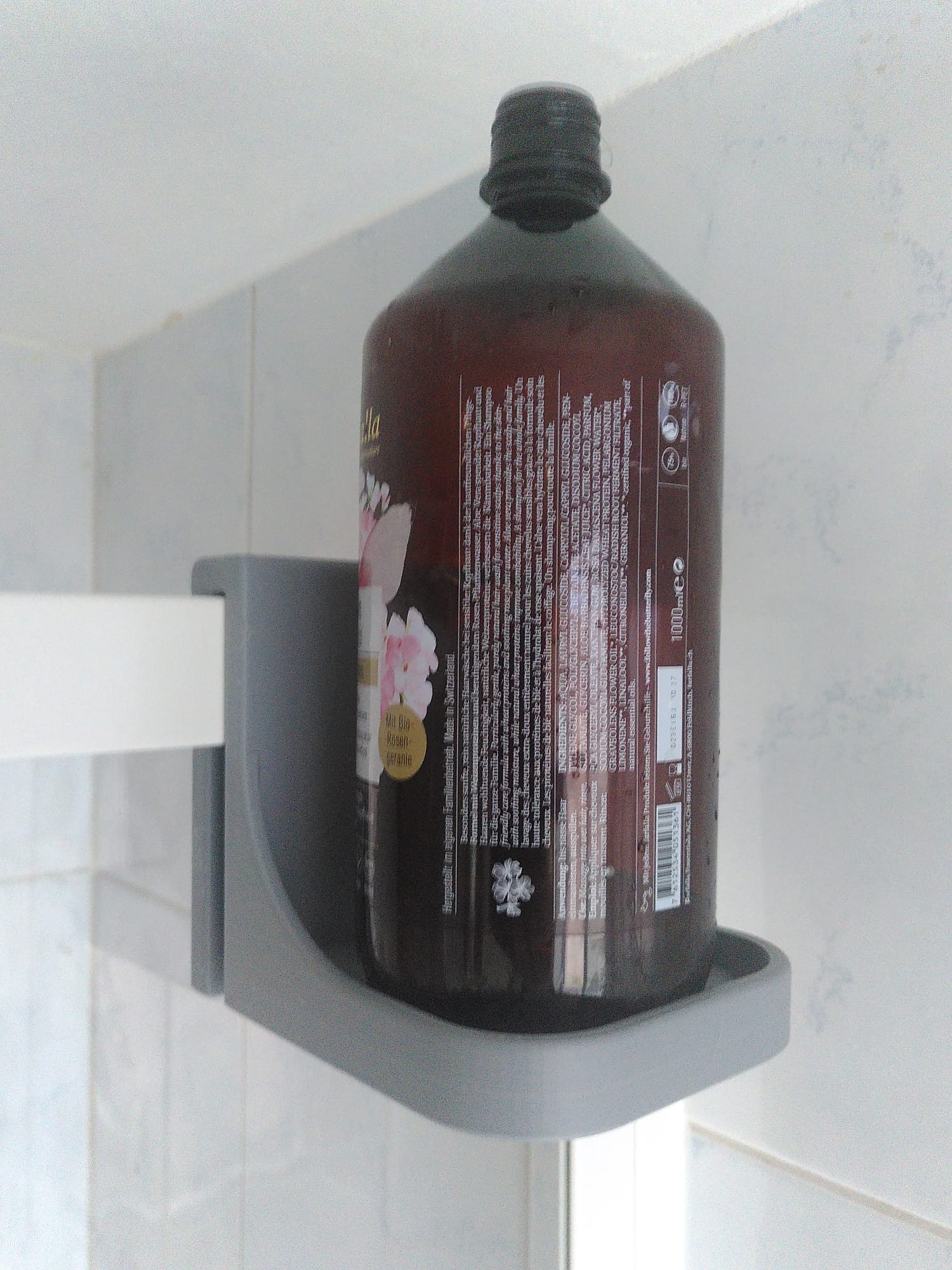 Shampoo bottle holder for shower wall