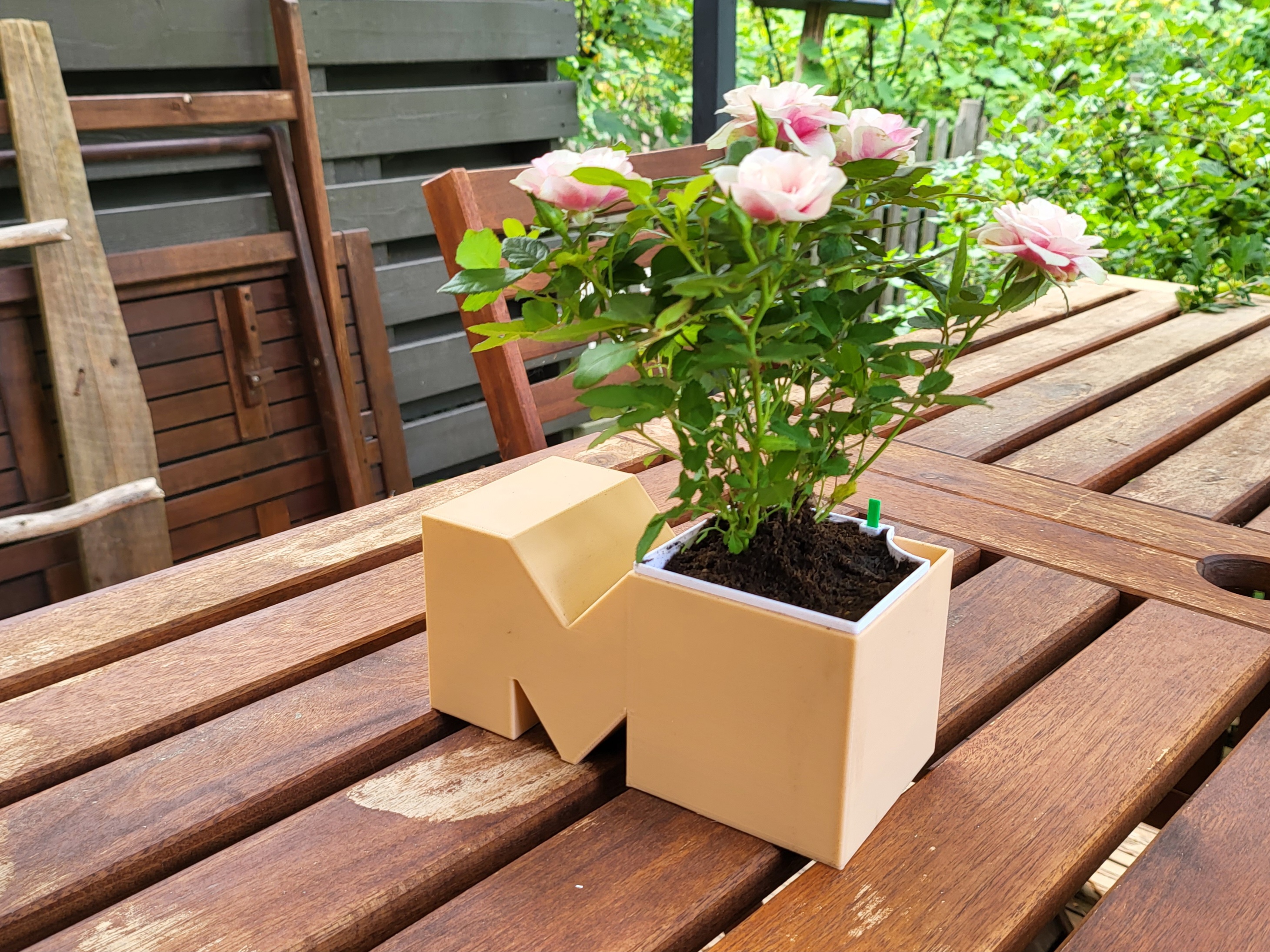 Letter M shaped self-watering planter with water indicator