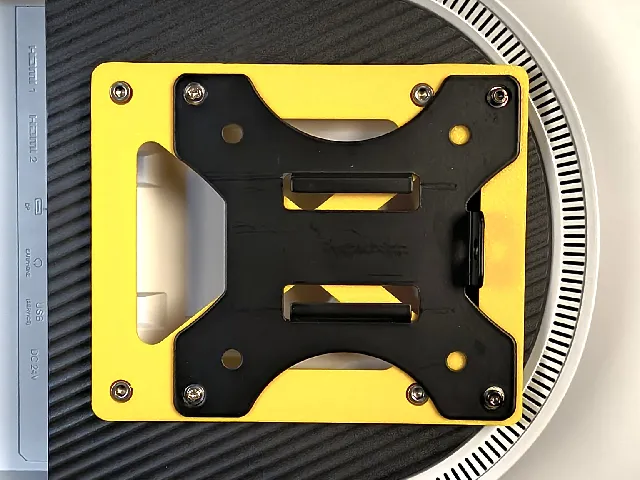 VESA 100x100 adapter to shift the monitor by 25mm.
