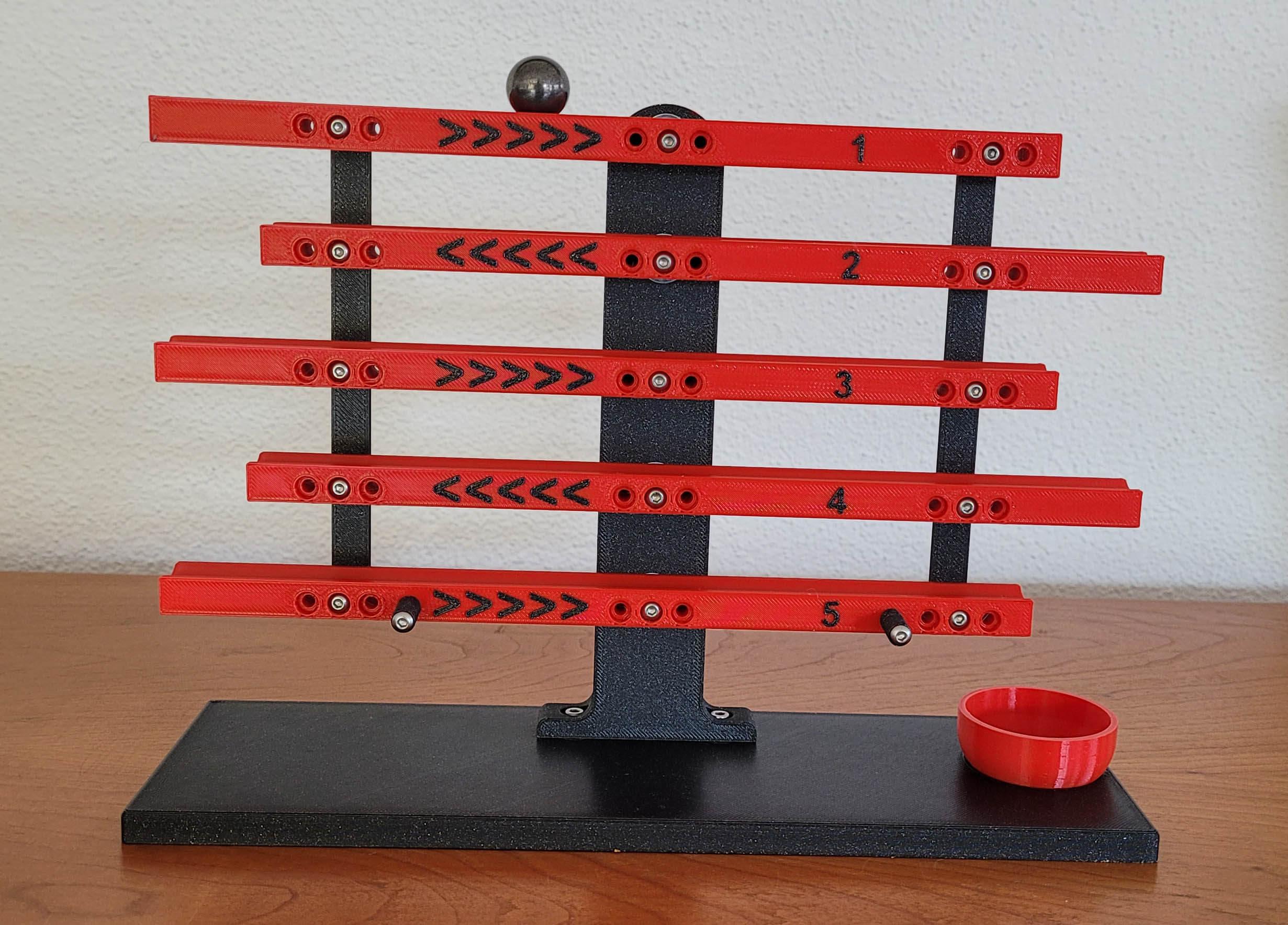 Skill game with a ball and cascading rails