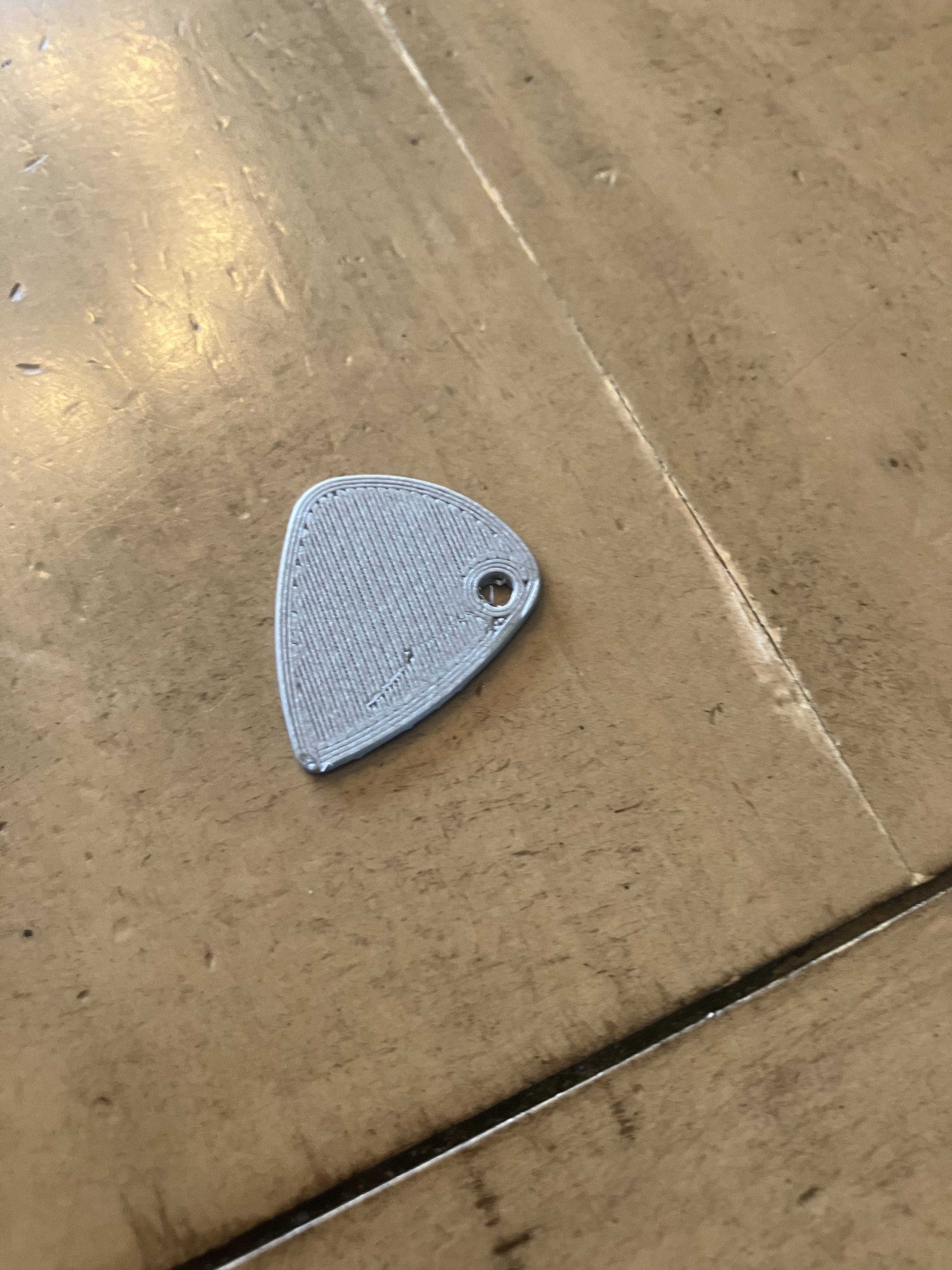 Guitar pick with keyring hole