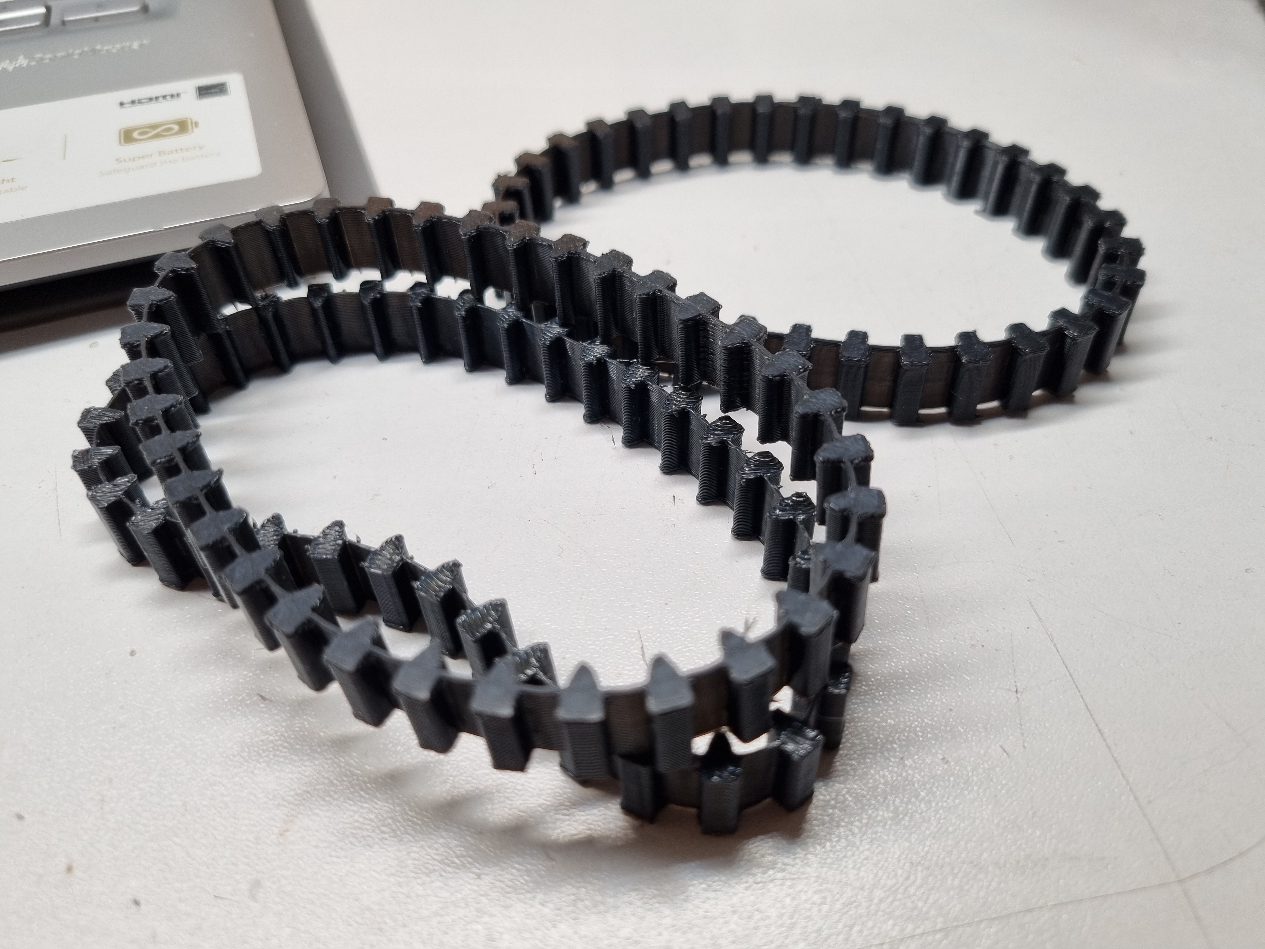 Flexible track and corresponding sprocket and idler wheel