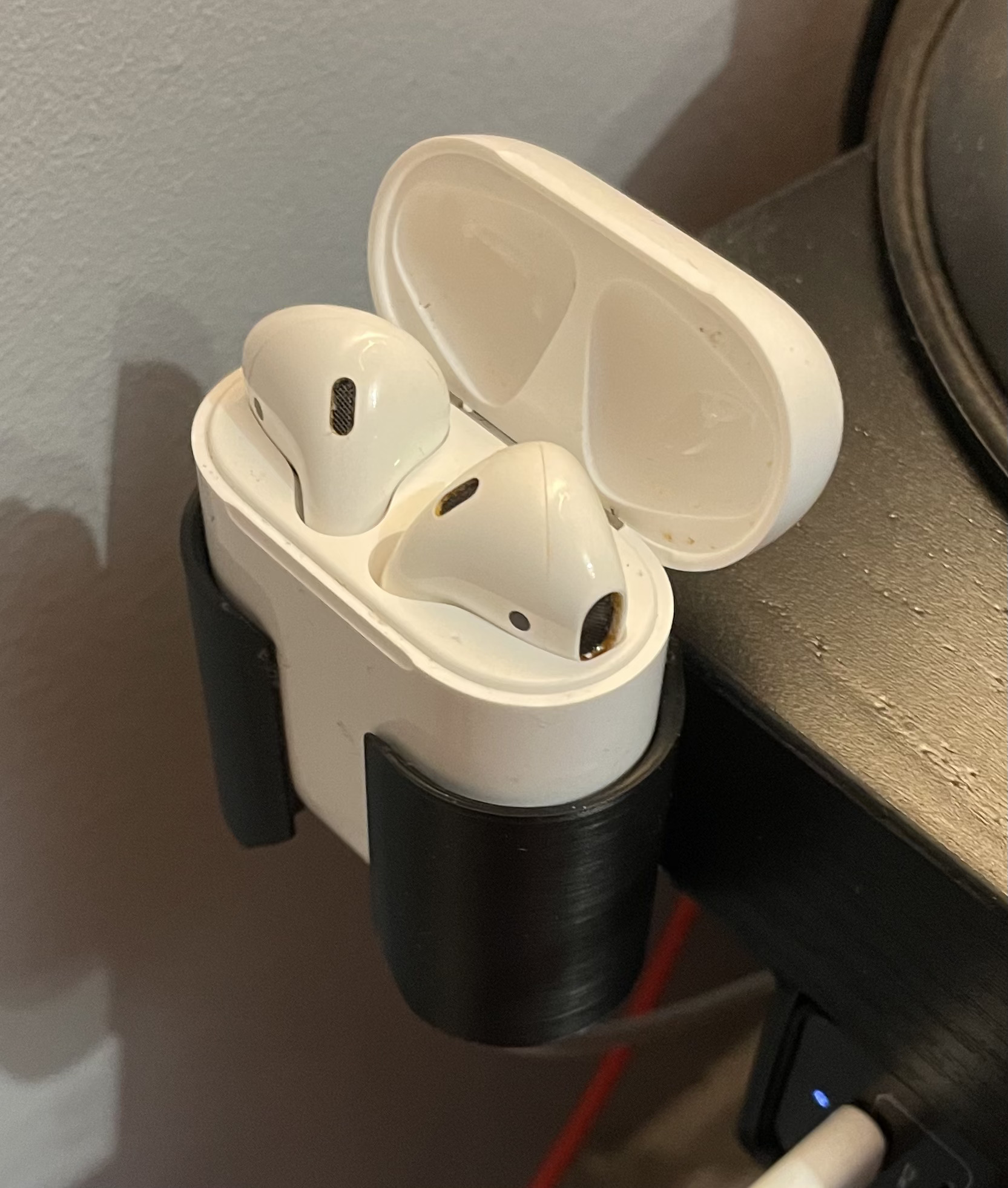 Apple AirPods case on IKEA desk mount