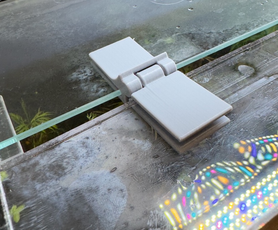 Hinge between acrylic and glass panels of aquarium lid by Bryson