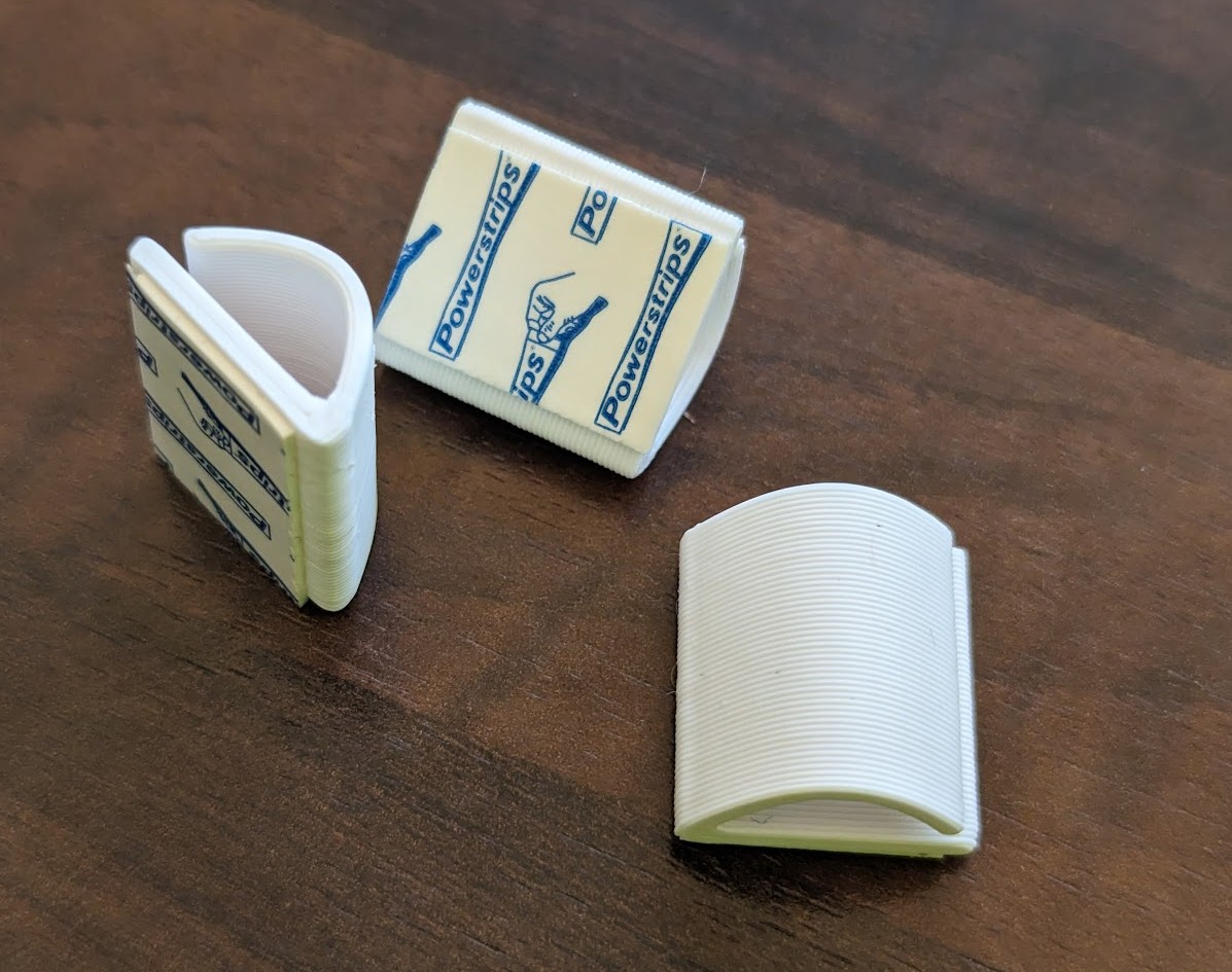 Cable management clip for Ikea Besta, Billy, and other 18mm (or wider) furniture with Tesa Powerstrip / 3M Command strips