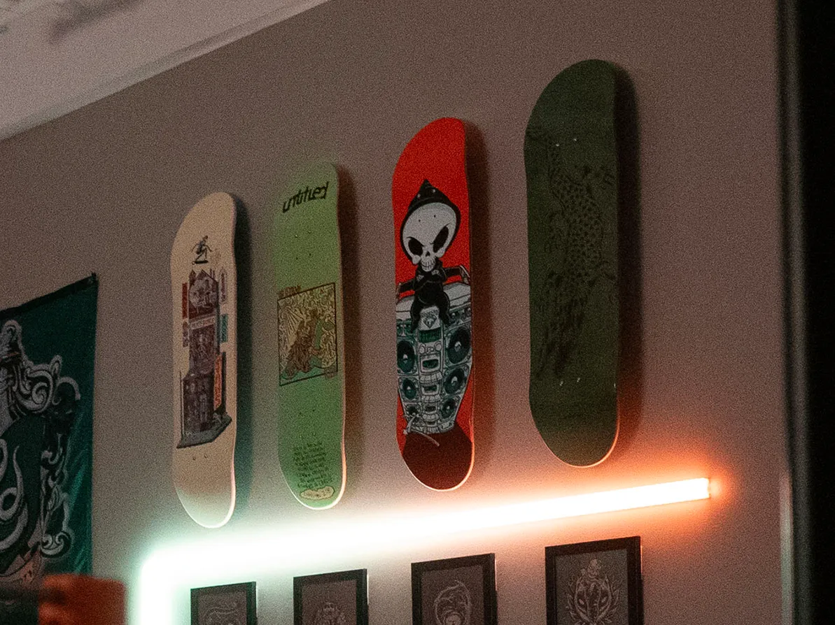 Skateboard deck mounted with command strips showing clean installation