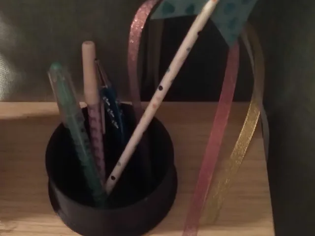 Ikea desk "Micke" pencil basket that covers hole.