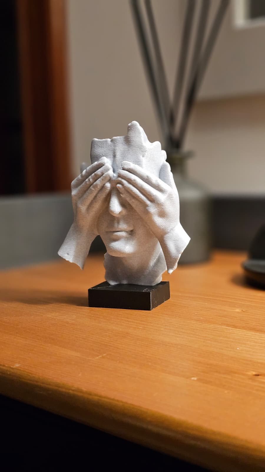 Escultura fragmentada con manos cubriendo los ojos