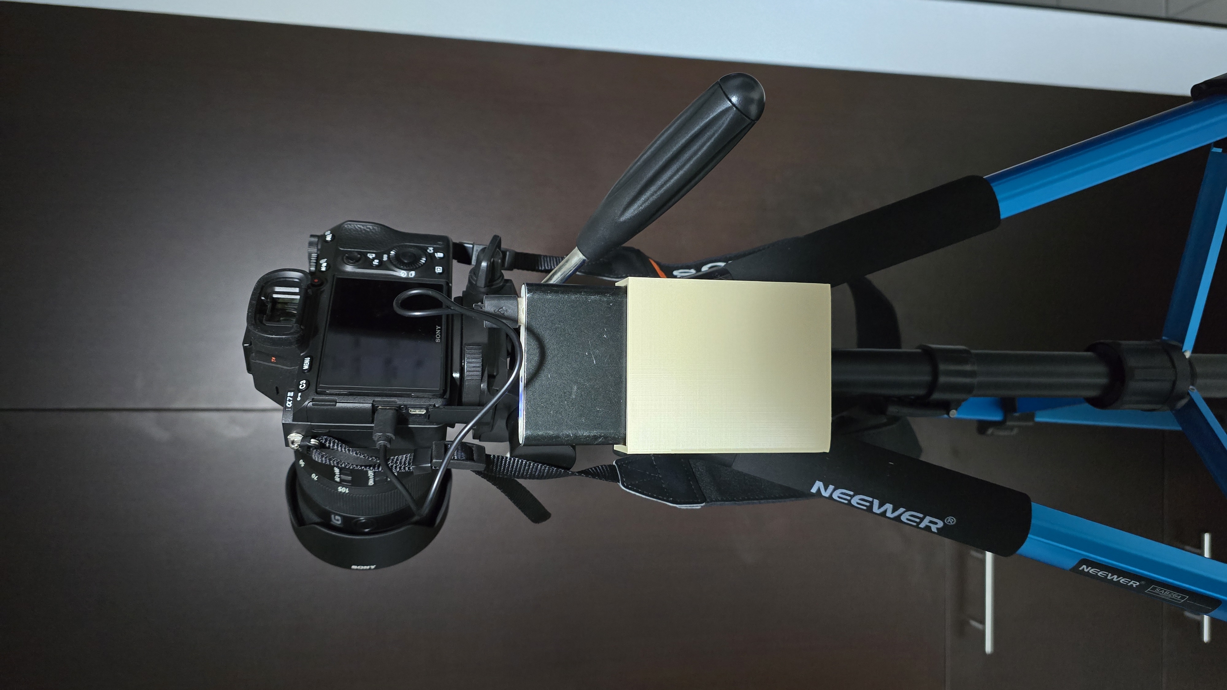 External battery holder for camera tripod mount