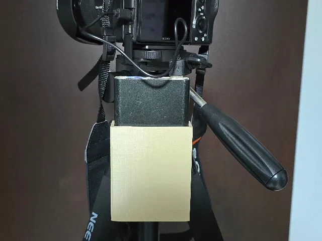 External battery holder for camera tripod mount