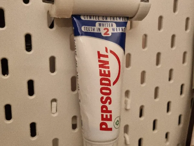 Skadis toothpaste holder for ratchet toothpaste tube squeezer