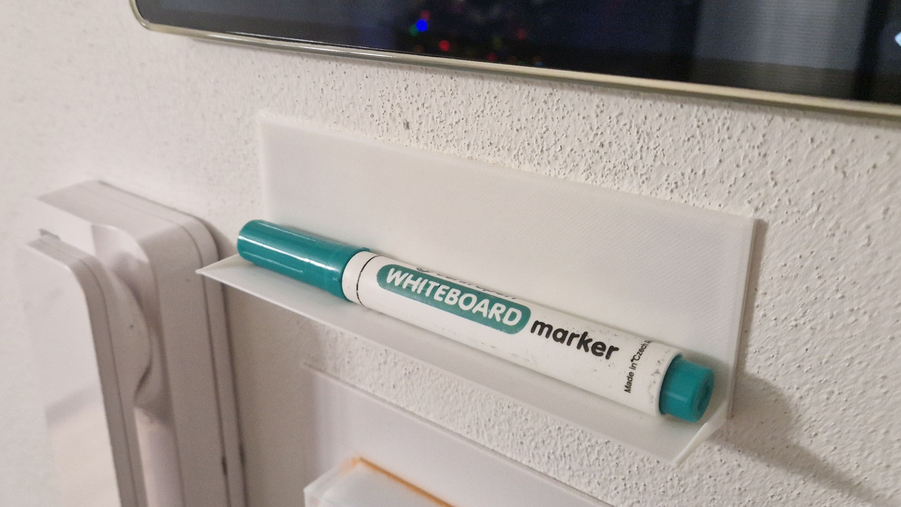 Marker shelf for a whiteboard.